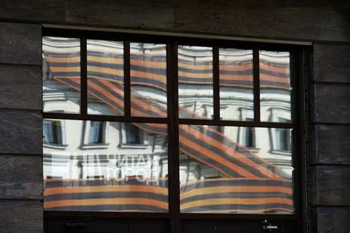 A huge letter Z, which has become a symbol of the Russian military, is reflected in an office building in a street in Moscow, Russia, Friday, May 6, 2022. Red Soviet flags and orange-and-black striped military ribbons are on display in Russian cities and towns. Neighborhoods are staging holiday concerts. Flowers are being laid by veterans' groups at monuments to the Great Patriotic War, as World War II is known in the country. At first glance, preparations for Monday's celebration of Victory Day