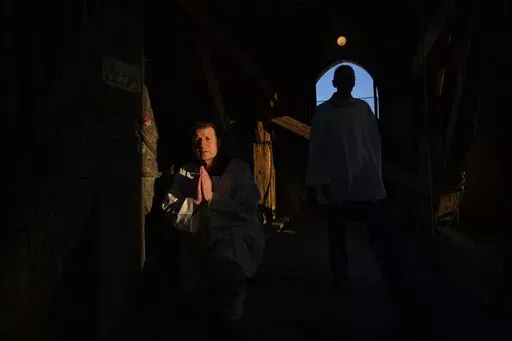 Retired policeman, Volodymyr Ilnytskyi, 55, prays before ringing the bell of the Latin Cathedral in Lviv, western Ukraine, Thursday, March 24, 2022. (AP Photo/Nariman El-Mofty)