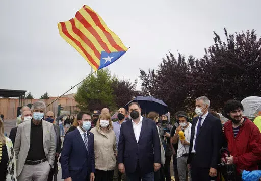 Former deputy president of the Catalan regional government Oriol Junqueras, centre, walks with the current Catalonian president Pere Aragones, 2nd left, in front of an "estelada" or Catalan pro-independence flag after being released from the Lledoners prison in Sant Joan de Vilatorrada near Barcelona, Spain, June 23, 2021. The phones of dozens of pro-independence supporters in Spain's northeastern Catalonia, including the regional chief and other elected officials, were hacked with controversial