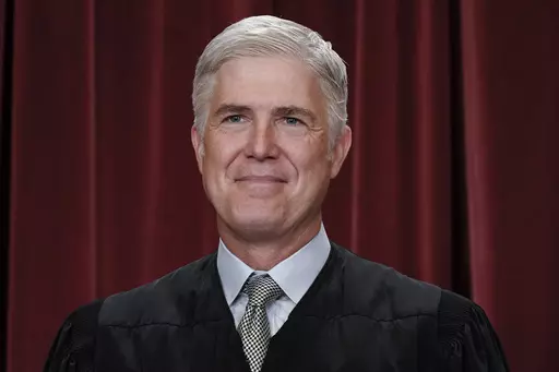Associate Justice Neil Gorsuch joins other members of the Supreme Court as they pose for a new group portrait, at the Supreme Court building in Washington, Friday, Oct. 7, 2022. Gorsuch called emergency measures taken during the COVID-19 crisis that killed more than 1 million Americans perhaps “the greatest intrusions on civil liberties in the peacetime history of this country.” The 55-year-old conservative justice pointed to orders closing schools, restricting church services, mandating vac