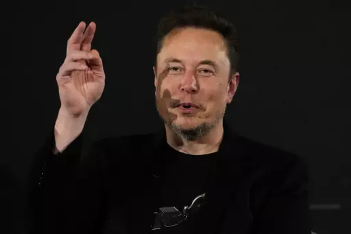 Elon Musk, owner of social media platform X, gestures during an event with Britain's Prime Minister Rishi Sunak in London on Nov. 2, 2023. The world could have its first trillionaire within a decade, anti-poverty organization Oxfam International said Monday Jan. 15, 2024 in its annual assessment of global inequalities timed to the gathering of political and business elites at the Swiss ski resort of Davos. (AP Photo/Kirsty Wigglesworth, Pool, File)