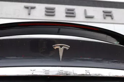 In this April 26, 2020 photo, the company logo shines off the rear deck of an unsold 2020 Model X at a Tesla dealership in Littleton, Colo. Tesla’s sales from April through June 2022 fell to their lowest quarterly level since last fall as supply chain issues and pandemic restrictions in China hobbled production of its electric vehicles. (AP Photo/David Zalubowski, File)