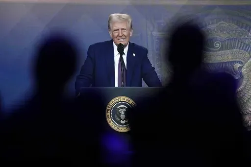 People follow a virtual speech of President Donald Trump at the annual meeting of the World Economic Forum in Davos, Switzerland, Jan. 23, 2025. (AP Photo/Markus Schreiber, File)