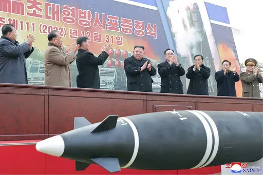 In this photo provided by the North Korean government, North Korean leader Kim Jong Un, center, attends a ceremony of donating 600mm super-large multiple launch rocket system at a garden of the Workers’ Party of Korea headquarters in Pyongyang, North Korea Saturday, Dec. 31, 2022. Independent journalists were not given access to cover the event depicted in this image distributed by the North Korean government. The content of this image is as provided and cannot be independently verified. Korea