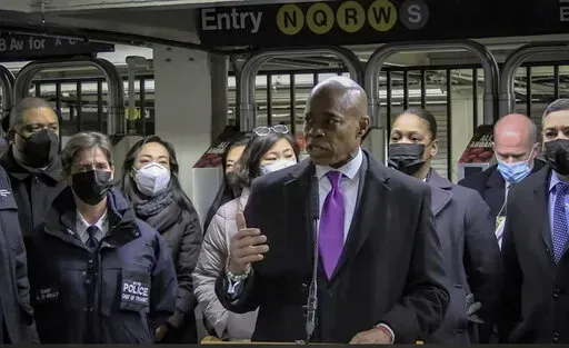 In this livestream frame grab from video provided by NYPD News, Mayor Eric Adams, foreground, with city law officials, speaks at a news conference inside a subway station after a woman was pushed to her death in front of a subway train at the Times Square station, Saturday, Jan. 15, 2022, in New York. (NYPD News via AP)