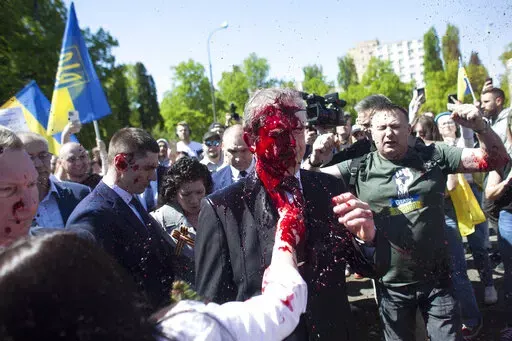 Russian Ambassador to Poland, Ambassador Sergey Andreev is covered with red paint in Warsaw, Poland, Monday, May 9, 2022. Protesters have thrown red paint on the Russian ambassador as he arrived at a cemetery in Warsaw to pay respects to Red Army soldiers who died during World War II. Ambassador Sergey Andreev arrived at the Soviet soldiers cemetery on Monday to lay flowers where a group of activists opposed to Russia’s war in Ukraine were waiting for him. (AP Photo/Maciek Luczniewski)