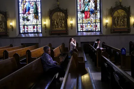 A parishioner prays at St. Peter the Apostle Catholic Church in Reading, Pa., on Sunday, June 16, 2024. Reading is 67% Latino, according to U.S. Census figures, and home to high concentrations of people of Dominican and Puerto Rican heritage — as well as Colombians and Mexicans, who own restaurants and other businesses around town. (AP Photo/Luis Andres Henao)