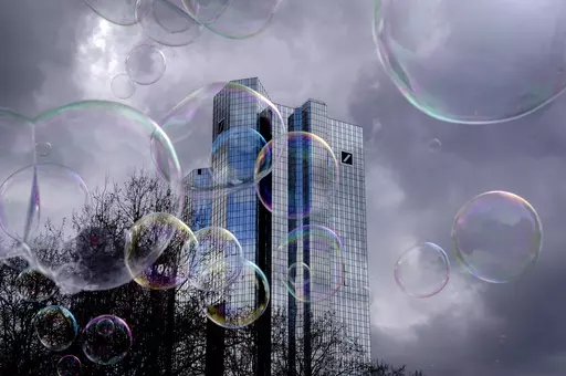 Bubbles made by a soap bubble artist, fly in front of the headquarters of Deutsche Bank in Frankfurt, Germany, Friday, March 24, 2023. (AP Photo/Michael Probst)