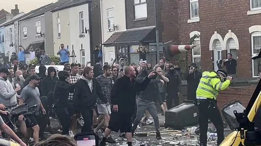 An unruly crowd clash with police, Tuesday, July 30, 2024, in Southport, northwest England, near where three girls were stabbed to death in a dance class the day before. The violence erupted shortly after a peaceful vigil was attended by hundreds in the center of Southport to mourn the 13 victims of the stabbings, including seven still in critical condition. (Richard McCarthy/PA via AP)