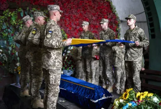 Servicemen pay last respect at the coffin of Olga Simonova, 34, a Russian woman who was killed in the Donetsk region while fighting on Ukraine's side in the war with her native country, in a crematorium in Kyiv, Ukraine, Friday, Sept. 16, 2022. (AP Photo/Roman Hrytsyna)
