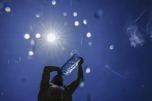 A man pours cold water onto his head to cool off on a sweltering hot day in the Mediterranean Sea in Beirut, Lebanon, July 16, 2023. European climate monitoring organization made it official: July 2023 was Earth's hottest month on record by a wide margin. (AP Photo/Hassan Ammar, File)