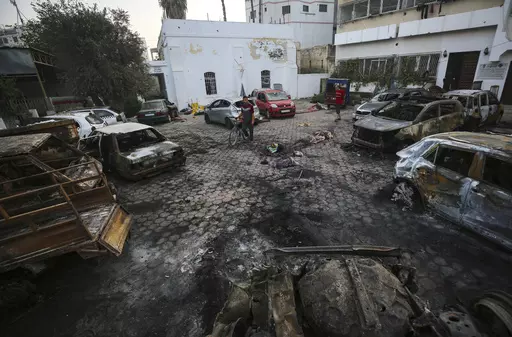 Men look over the site of a deadly explosion at Al-Ahli Hospital in Gaza City, Wednesday, Oct. 18, 2023. This photo and others taken the morning after the explosion show no evidence of a large crater at the impact site that would be consistent with a large bomb such as those dropped by Israeli aircraft in other recent strikes. (AP Photo/Abed Khaled, File)
