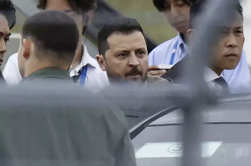 Ukrainian President Volodymyr Zelenskyy, center, walks to a car upon his arrival at Hiroshima Airport to attend the Group of Seven (G7) nations' meetings in Hiroshima, western Japan Saturday, May 20, 2023. (Kyodo News via AP)