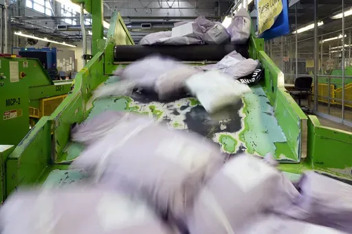 Parcels slide down a ramp after being scanned at the U.S. Customs and Border Protection overseas mail inspection facility at Chicago's O'Hare International Airport Feb. 23, 2024, in Chicago. (AP Photo/Charles Rex Arbogast, File)