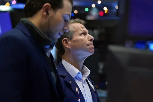 Trader Robert Charmak, right, works on the floor of the New York Stock Exchange, Tuesday, Dec. 7, 2021.  (AP Photo/Richard Drew, File)