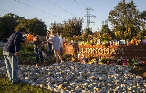 Raleigh's Hedingham neighborhood entrance sign becomes a makeshift memorial Saturday, Oct. 15, 2022, following Thursday's mass shooting in the neighborhood and on the nearby Neuse River greenway trail. (Travis Long/The News & Observer via AP)