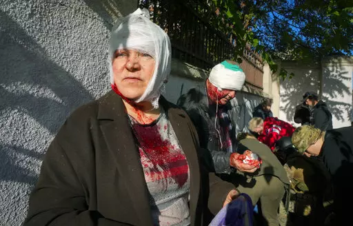 People receive medical treatment at the scene of Russian shelling, in Kyiv, Ukraine, Monday, Oct. 10, 2022. The Russian missiles that rained down Monday on cities across Ukraine, bringing fear and destruction to areas that had seen months of relative calm, are an escalation in Moscow's war against its neighbor. But military analysts say it’s far from clear whether the strikes mark a turning point in a war that has killed thousands of Ukrainians and sent millions fleeing from their homes. (AP P