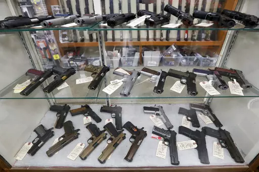 Semi-automatic handguns are displayed at shop in New Castle, Pa., March 25, 2020. A federal appeals court has dealt a legal setback to the Biden administration on guns in a lawsuit challenging tighter regulations on stabilizing braces, an accessory used in several mass shootings. The Fifth Circuit Court of Appeals temporarily blocked an administration rule from going into effect for the gun owners and groups who filed the lawsuit. The order came shortly before a deadline for people to register t
