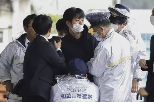 A man who was later identified as Ryuji Kimura is arrested after what appeared to be a pipe bomb was thrown at Japanese Prime Minister Fumio Kishida during his visit at a port in Wakayama, western Japan, on April 15, 2023. Prosecutors in Japan indicted the 24-year-old man Wednesday, Sept. 6, 2023 on attempted murder and other charges in the explosive attack on Prime Minister Fumio Kishida in April, Japanese media reported. (Kyodo News via AP, File)