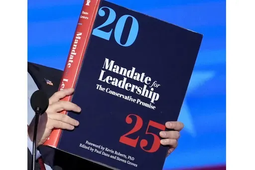 A copy of Project 2025 is held during the Democratic National Convention, Aug. 21, 2024, in Chicago. For a year, Project 2025 has endured as a persistent force in the presidential election. It’s rare for a complex 900-page policy book to figure so dominantly in a political campaign. (AP Photo/J. Scott Applewhite)