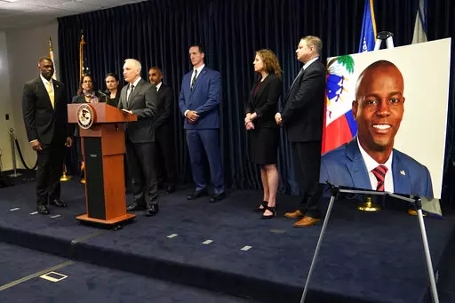Matthew Olsen, Assistant Attorney General for National Security, speaks during a news conference, Tuesday, Feb. 14, 2023, in Miami. U.S. authorities have arrested four more people in the slaying of Haitian President Jovenel Moïse, including the owner of a Miami-area security company that hired former soldiers from Colombia for the mission. At left is Markenzy Lapointe, U.S. Attorney for the Southern District of Florida. At right is an image of Haitian President Jovenel Moïse, (AP Photo/Lynne S