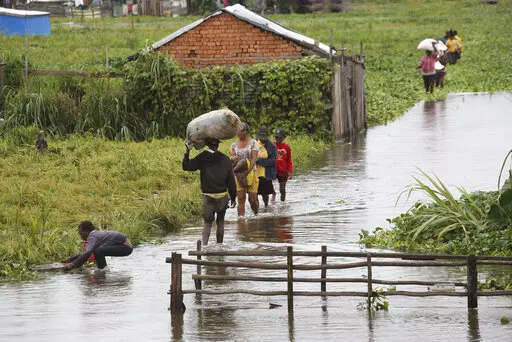Residents wade through flood water around their homes after heavy rain in Antananarivo, on Jan. 19, 2022. Rich countries say they will spend about $25 billion by 2025 to boost Africa’s efforts to adapt to climate change as the continent continues to struggle with drought, cyclones and extreme heat, according to officials at a summit in Rotterdam in the Netherlands. (AP Photo/Alexander Joe, File)