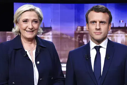 FILE- French presidential election candidate for the far-right Front National party, Marine Le Pen, left, and French presidential election candidate for the En Marche ! movement, Emmanuel Macron, pose prior to the start of a live broadcast face-to-face televised debate in La Plaine-Saint-Denis, north of Paris, May 3, 2017. It's meant to be the climax of France's presidential campaign. Centrist French President Emmanuel Macron and far-right contender Marine Le Pen are facing each other Wednesday 