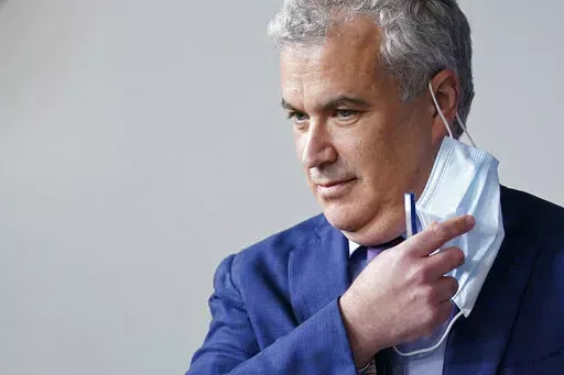 White House COVID-19 Response Coordinator Jeff Zients removes a face mask as he prepares to speak at a press briefing at the White House in Washington, April 13, 2021. The White House said Wednesday, Feb. 9, 2022, that it was beginning to prepare for the next phase of the pandemic response amid growing impatience for the federal government to ease up. Zients said officials have started consultations in recent weeks with state and local leaders and public health officials “on steps we should be