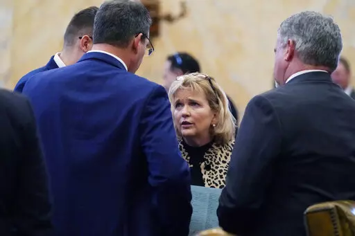 Rep. Becky Currie, R-Brookhaven, center, lobbies colleagues to co-sign a bill following adjournment on the first day of the 2023 Legislature at the Mississippi Capitol in Jackson, Tuesday, Jan. 3, 2023. (AP Photo/Rogelio V. Solis)
