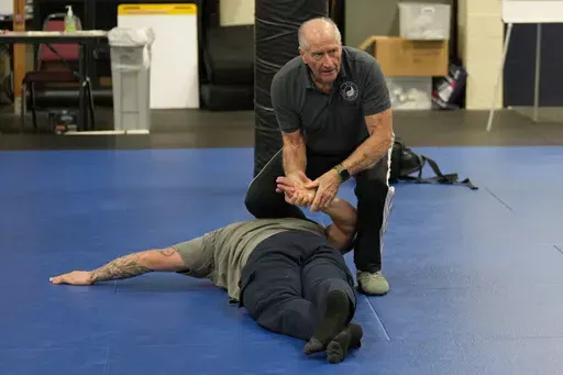 Instructor Dave Rose demonstrates a prone handcuffing position on a student during an Arrest & Control Instructor course in Sacramento, Calif., on Thursday, Jan. 18, 2024. Rose has trained generations of officers that prone restraint is safe. His pupils are instructors who take his training back to their departments. (AP Photo/Rich Pedroncelli)