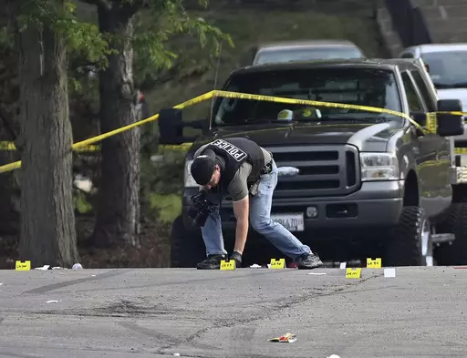 A police officer works the scene of an overnight mass shooting at a strip mall in Willowbrook, Ill., June 18, 2023. A suburban Chicago teen is facing weapons charges in connection with a June shooting where one person died and 22 others were injured, authorities said Friday, Oct. 6, 2023. (AP Photo/Matt Marton, File)