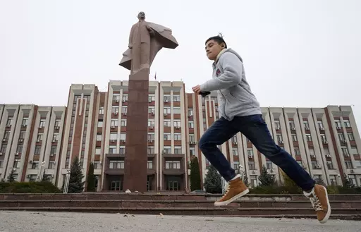 A boy runs past a statue of Soviet Union founder Vladimir Lenin in Tiraspol, the capital of the Russia-backed breakaway region of Transnistria, in Moldova on Nov. 1, 2021. Since Russia fully invaded Ukraine two years ago, a string of incidents in Transnistria have periodically raised the specter that European Union candidate Moldova could also be in Moscow's crosshairs. (AP Photo/Dmitri Lovetsky, File)