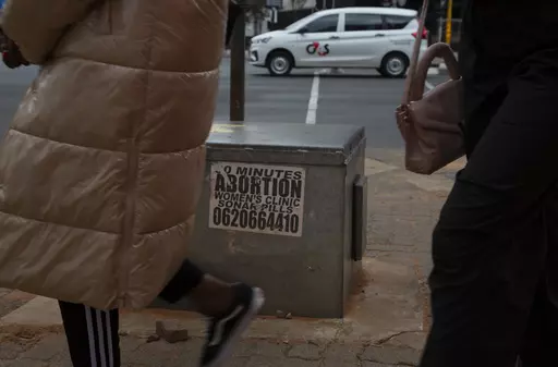 Women pass a sticker advertising abortion pills on a sidewalk in Johannesburg, Wednesday June 28, 2023. When the U.S. Supreme Court overturned the national right to an abortion a year ago, it shook efforts to legalize and make abortions safer in Africa. Sub-Saharan Africa has the world's highest rate of unintended pregnancies, and 77% of abortions are estimated to be unsafe. (AP Photo/Denis Farrell)