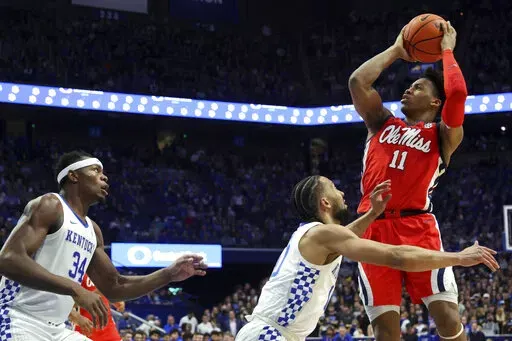 Mississippi's Matthew Murrell (11) shoots while defended by Kentucky's Davion Mintz, middle, and Oscar Tshiebwe (34) during the second half of an NCAA college basketball game in Lexington, Ky., Tuesday, March 1, 2022. (AP Photo/James Crisp)