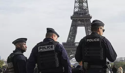 Police officers patrol the Trocadero plaza near the Eiffel Tower in Paris, Tuesday, Oct. 17, 2023. Police have arrested a man climbing on the Eiffel Tower. The drama temporarily stranded a crowd at the top. Among those trapped was a Washington, D.C., couple who decided during the wait to get married and an Associated Press reporter who got their story. Amir Khan had been planning to propose to Kate Warren later Thursday in a Paris garden away from the crowds, with a romantic dinner on the River 