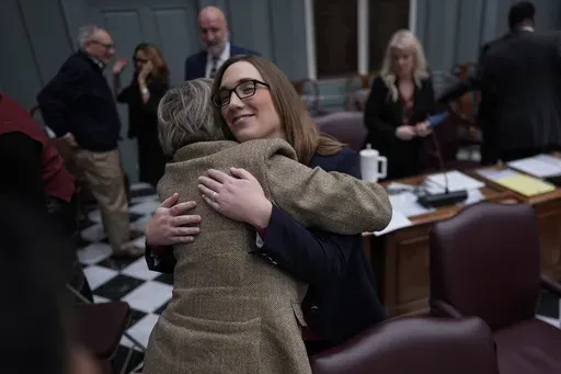 U.S.-Rep.-elect Sarah McBride, D-Del., hugs Delaware State Democrat Senator Laura Sturgeon from District 4 on the Senate floor during a special session, McBride's last day as a Delaware state senator, at the Delaware Legislative Hall in Dover, Del., Monday, Dec. 16, 2024. (AP Photo/Carolyn Kaster)