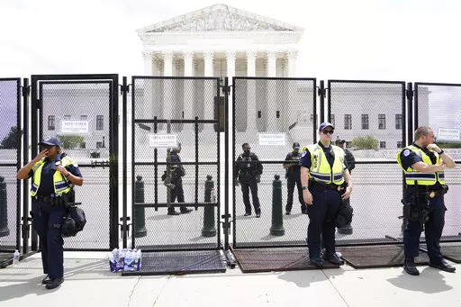 Authorities stand guard by a fence outside the Supreme Court following Supreme Court's decision to overturn Roe v. Wade in Washington, Friday, June 24, 2022. The Supreme Court has ended constitutional protections for abortion that had been in place nearly 50 years, a decision by its conservative majority to overturn the court's landmark abortion cases.(AP Photo/Jacquelyn Martin)