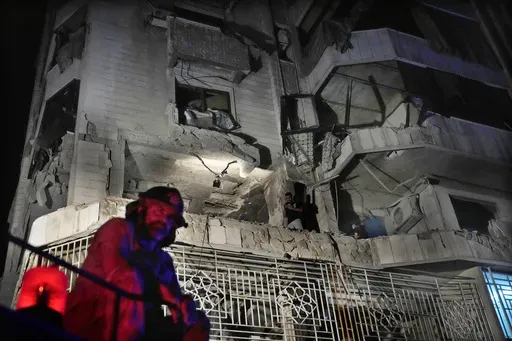 A firefighter stands in front of an apartment hit by an Israeli airstrike, in Beirut, Lebanon, Thursday, Oct. 3, 2024. (AP Photo/Hussein Malla)