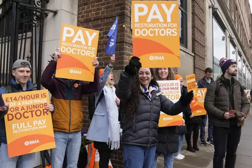 Junior doctors hold placards on a picket line outside St Mary's Hospital in London, Tuesday, March 14, 2023. Unions representing hundreds of thousands of nurses, ambulance crews and other health care workers in England reached a deal Thursday, March 16, 2023, to resolve months of disruptive strikes for higher wages, though the pact didn't include doctors. (AP Photo/Alastair Grant, File)