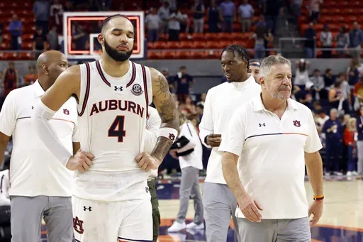 Auburn forward Johni Broome (4) and head coach Bruce Pearl walk off the court after losing to Alabama in overtime in an NCAA college basketball game, Saturday, March 8, 2025, in Auburn, Ala. (AP Photo/Butch Dill)