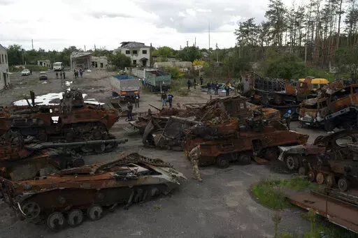 A Ukrainian serviceman and journalists walk between destroyed Russian equipment placed in an area at the recaptured town of Lyman, Ukraine, Wednesday, Oct. 5, 2022. (AP Photo/Leo Correa)