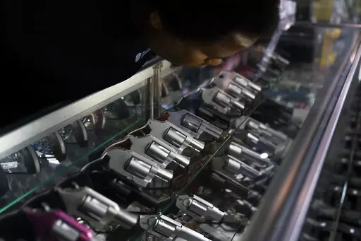 Sales associate Elsworth Andrews arranges guns on display at Burbank Ammo & Guns in Burbank, Calif., Thursday, June 23, 2022. The Supreme Court has ruled that Americans have a right to carry firearms in public for self-defense, a major expansion of gun rights. The court struck down a New York gun law in a ruling expected to directly impact half a dozen other populous states. (AP Photo/Jae C. Hong)