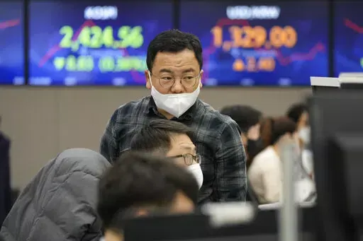 Currency traders watch monitors at the foreign exchange dealing room of the KEB Hana Bank headquarters in Seoul, South Korea, Wednesday, Nov. 30, 2022. Asian shares were mostly lower Wednesday ahead of a closely watched speech by the Federal Reserve chief that may give clues about future interest rate hikes. (AP Photo/Ahn Young-joon)