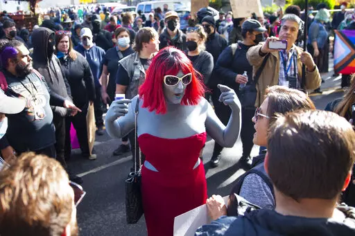 Drag performer Emma Lavin, center, attempts to find middle ground with protesters against a drag queen story time outside Old Nick's Pub in Eugene, Ore., Sunday, Oct. 23, 2022. The art and entertainment form of drag has been miscast in recent months by right-wing activists and politicians who complain about the “sexualization” or “grooming” of children. The recent headlines about disruptions of drag events and their portrayal as sexual and harmful to children can obscure the intent of th
