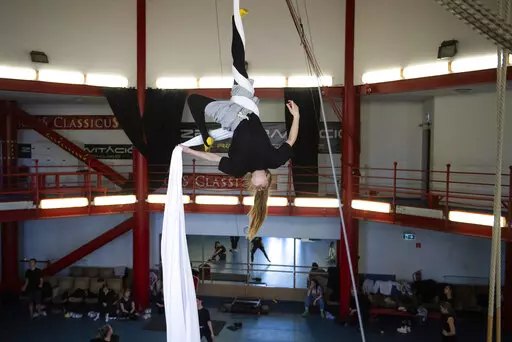 A Ukrainian circus artist who fled the war in Ukraine trains in a circus practice facility in Budapest, Hungary, Tuesday, March 22, 2022. Around 100 Ukrainian circus art students aged 5-20, with their adult chaperones, escaped the embattled cities of Kharkiv and Kyiv amid Russian bombings. In neighboring Hungary, fellow circus devotees extended help and solidarity, taking them in and allowing them to continue training in the safety of the capital, Budapest. (AP Photo/Anna Szilagyi)