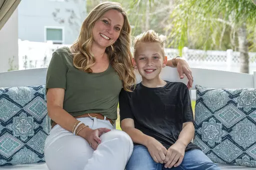 Holly Nover sits with her son, Colton Nover, 10, on a backyard swing at their home Wednesday, Feb. 16, 2022, in St. Johns, Fla. Holly, a speech pathologist active in the National Stuttering Association, said many people will surely be interested in trying stuttering medications – although not her. She is happy with her life as it is and has accepted her stuttering, she said. If her son were struggling and wanted to try medication as a teen, however, she’d be open to the idea. (AP Photo/Fran 