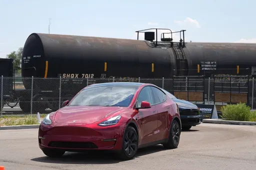 Drivers guide 2024 a Tesla Model 3 sedan and Model X utility vehicle, rear, along a test track at the Electrify Expo in The Yards on July 14, 2024, in north Denver. (AP Photo/David Zalubowski, File)