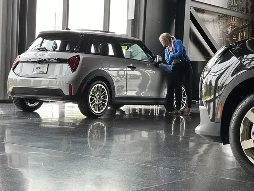 A prospective buyer examines a 2025 Cooper S hardtop on display on the showroom floor of a Mini dealership Monday, July 22, 2024, in Highlands Ranch, Colo. (AP Photo/David Zalubowski)