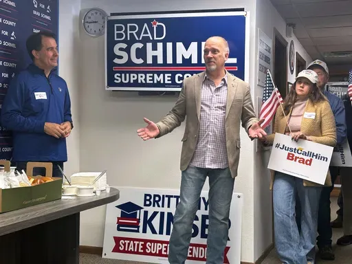 Wisconsin Supreme Court candidate Brad Schimel, center, speaks with supporters as former Gov. Scott Walker, left, watches on Monday, March 31, 2025, in Madison, Wis. (AP Photo/Scott Bauer)