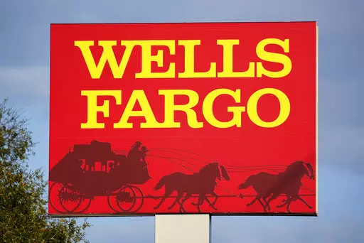 A Wells Fargo sign stands in front of a branch of the bank in Bradenton, Fla., Tuesday, Feb. 22, 2022. Consumer banking giant Wells Fargo is being ordered to pay $3.7 billion in fines and refunds to customers by U.S. government regulators, the largest fine to date against the bank. (AP Photo/Gene J. Puskar, File)